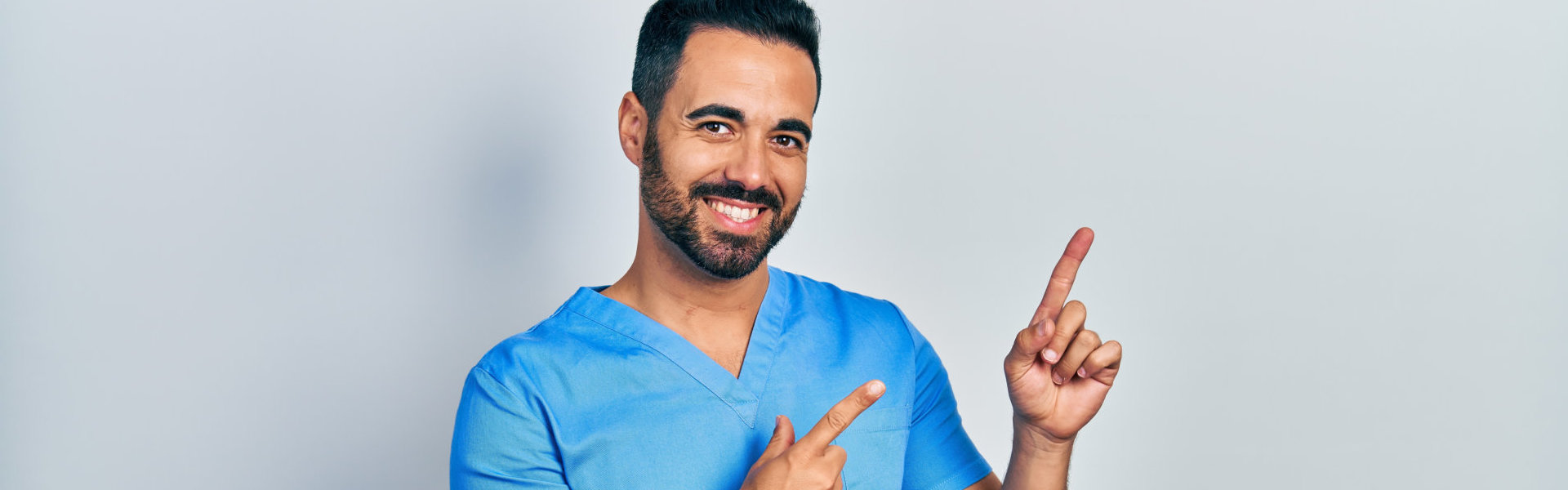 aide smiling while pointing his fingers
